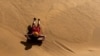 นักท่องเที่ยวเล่นแซนด์บอร์ดบนเนินทราย ในวัลวิส เบย์ นามิเบีย 26 กุมภาพันธ์ 2024 (รอยเตอร์)