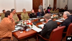 FILE - In this photo released by the Press Information Department, Pakistan Prime Minister Imran Khan, left, chairs a meeting of the country's National Security Committee, in Islamabad, Pakistan, Feb. 21, 2019.