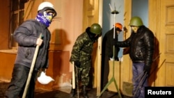 Anti-government protesters stand at the entrance of the Ministry of Justice in central Kyiv, Jan. 27, 2014.