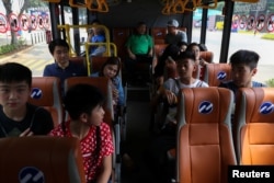 Spectators ride a shuttle bus inside the Gelora Bung Karno sports complex, ahead of the 2018 Asian Games in Jakarta, Indonesia, Aug. 17, 2018.