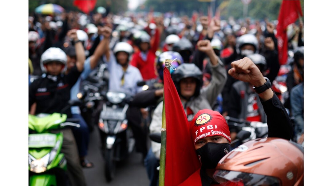 Para pekerja meneriakkan slogan-slogan saat protes menuntut kenaikan upah di Jakarta 1 November 2013. (Foto: Reuters/Beawiharta)