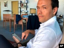 French Digital Affairs junior minister Cedric O demonstrates how to use the French app StopCovid meant to trace the virus' future spread on during an interview with the Associated Press in Paris, Friday, May 29, 2020.