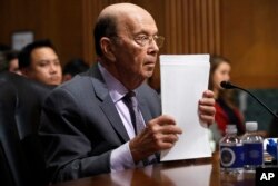 Secretary of Commerce Wilbur Ross straightens his papers during a Senate Finance Committee hearing on tariffs, on Capitol Hill, June 20, 2018 in Washington.