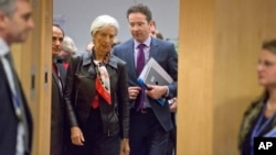 Managing Director of IMF Christine Lagarde (l) arrives with Dutch Finance Minister Jeroen Dijsselbloem for a meeting of eurogroup finance ministers in Brussels, Feb. 11, 2015.