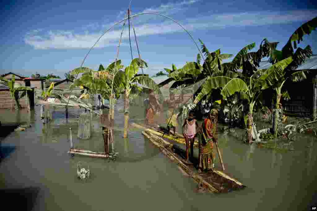 A family rows a banana raft in a flood affected area in Morigaon district, east of Gauhati, northeastern Assam state, India.