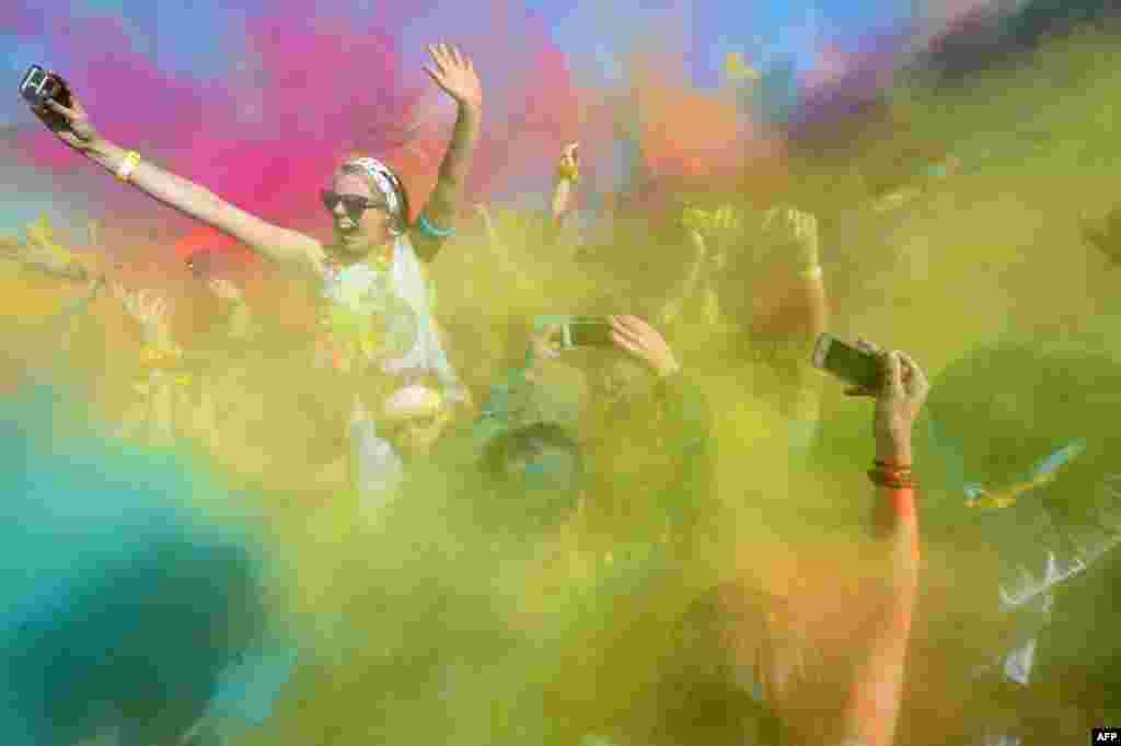 Para pelari memeriahkan perayaan festival warna di Taman Centennial, Sydney, Australia.