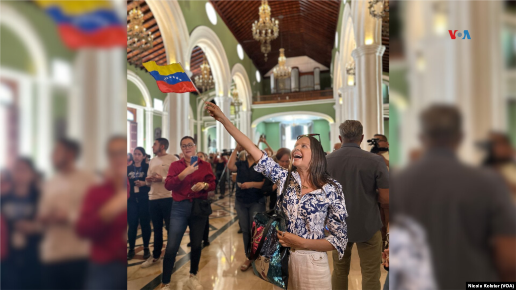 Una mujer celebra, mientras alza una bandera de Venezuela, que el papa Francisco haya aprobado la canonización del beato venezolano, el primer santo católico originario del país suramericano.&nbsp;