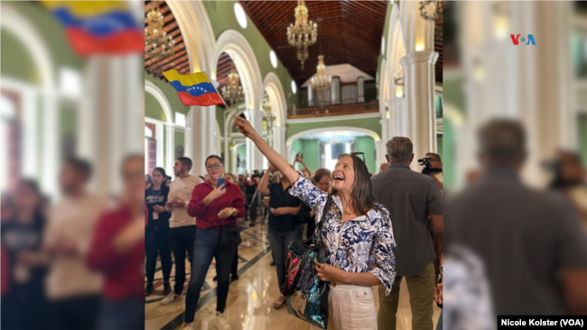 Una mujer celebra, mientras alza una bandera de Venezuela, que el papa Francisco haya aprobado la canonización del beato venezolano, el primer santo católico originario del país suramericano. 