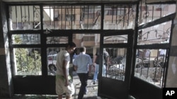 Lebanese citizens leave a destroyed building that was damaged during clashes erupted between pro- and anti-Syrian Sunni groups, in Beirut, Lebanon, May 21, 2012.