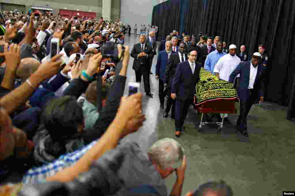 Worshippers and well-wishers take photographs as the casket with the body of the late-boxing champion Muhammad Ali is brought for his Jenazah, an Islamic funeral prayer, in Louisville, Ky., June 9, 2016. 