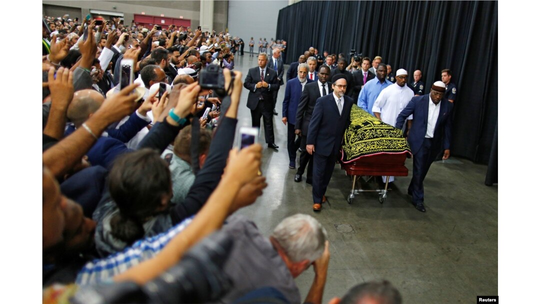 FILE - Worshippers and well-wishers take photographs as the casket with the body of the late-boxing champion Muhammad Ali is brought for his Jenazah, an Islamic funeral prayer, in Louisville, Ky., June 9, 2016.