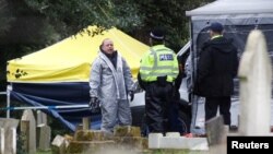Members of the emergency services in protective suits work at the site of the grave of Liudmila Skripal, wife of former Russian intelligence officer Sergei Skripal, at London Road Cemetery, in Salisbury, Britain, March 10, 2018.