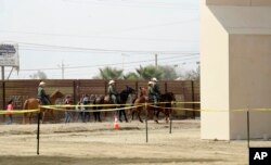 FILE - A group of people are detained by Border Patrol agents on horseback after crossing the border illegally from Tijuana, Mexico, near where prototypes for a border wall, right, were being constructed in San Diego, Oct. 19, 2017. More than 1,600 people arrested at the U.S.-Mexico border, including parents who have been separated from their children, are being transferred to federal prisons, U.S. immigration authorities confirmed, June 7, 2018.