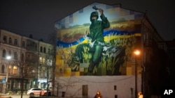 Na zidu je prikazan 19-godišnji vojnik iz Ukrajinske nacionalne garde Roman Holomba, koji je srušio sedam ruskih aviona i projektil sa prenosnim protivavionskim raketnim sistemom Igla, Kijev, Ukrajina, 19. januar, 2024. (Foto: AP/Efrem Lukatsky)