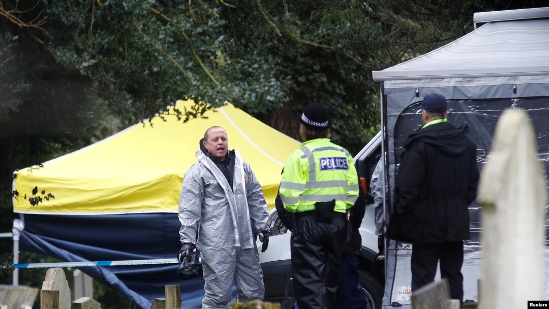 Anggota dinas darurat (mengenakan pakaian pelindung) di lokasi makam Liudmila Skripal, istri mantan perwira intelijen Rusia Sergei Skripal, di London Road Cemetery, di Salisbury, Inggris, 10 Maret 2018.
