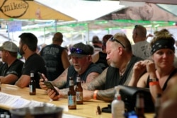 FILE - In this Aug. 7, 2020, file photo, people congregate at One-Eyed Jack's Saloon during the 80th annual Sturgis Motorcycle Rally in Sturgis, S.D. Federal/state law enforcement arrested eight persons seeking to purchase sex with minors.
