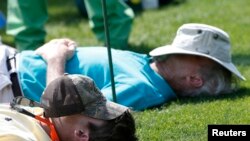 File - People nap on the 15th tee during Masters golf tournament in Augusta, Georgia, April 11, 2014. 