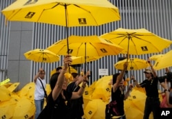 Protesters raise yellow umbrellas during a rally to mark the one year anniversary of "Umbrella Movement" outside the government headquarters in Hong Kong, Sept. 28, 2015.