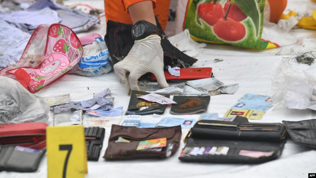 Seorang anggota tim BASARNAS mengumpulkan barang-barang pribadi yang diduga milik penumpang pesawat Lion Air JT610. 