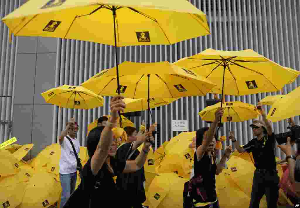 Protesters raise yellow umbrellas during a rally to mark the one year anniversary of "Umbrella Movement" outside the government headquarters in Hong Kong, Sept. 28, 2015. 