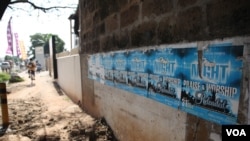 Posters promoting a nighttime religious revival are pictured alongside a busy road, in Accra, Ghana, Oct. 10,2014.(Chris Stein / VOA)