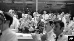 Astronaut Thomas Stafford, left, and Donald Slayton, Director of Flight Crew Operations, puff on big cigars and applaud as the Apollo 13 made a successful splashdown, April 17, 1970, Houston, Tex. 