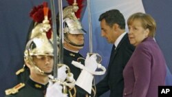 Germany's Chancellor Angela Merkel (R) walks with France's President Nicolas Sarkozy as they arrive at the G20 venue where world leaders gather in Cannes, France, November 2, 2011.