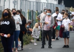 FILE - People queue at a testing site amid the coronavirus pandemic in Southend-on-Sea, Britain, Sept. 16, 2020.