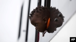 FILE: A child from Zimbabwe waits for a bus to depart for Harare, from a camp for those affected by anti-immigrant violence in Chatsworth, north of Durban April 19, 2015. 