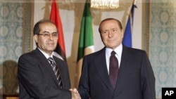 ນາຍົກລັດຖະມົນຕີອີຕາລີ ທ່ານ Silvio Berlusconi
ຈັບມືກັບທ່ານ Mahmoud Jibri ຮອງປະທານສະພາ ໄລຍະຂ້າມຜ່ານແຫ່ງຊາດ ຂອງພວກກະບົດລີເບຍ ທີ່ນະຄອນມີລານ ປະເທດອີຕາລີ (25 ສິງຫາ 2011)