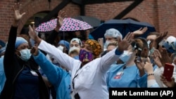 Healthcare workers react to the applause at Brooklyn's Kings County Hospital Center during the coronavirus pandemic April 24, 2020, in New York. (AP Photo/Mark Lennihan)