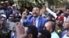 FILE - Jawar Mohammed, center, a member of the Oromo ethnic group who has been a public critic of Ethiopian Prime Minister Abiy Ahmed, addresses supporters outside his home in Addis Ababa, Oct. 24, 2019.