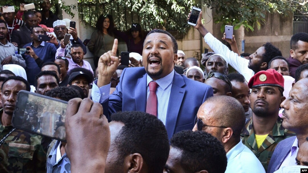 FILE - Jawar Mohammed, center, a member of the Oromo ethnic group who has been a public critic of Ethiopian Prime Minister Abiy Ahmed, addresses supporters outside his home in Addis Ababa, Oct. 24, 2019.