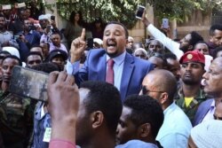 FILE - Jawar Mohammed, center, addresses supporters outside his home in Addis Ababa, Oct. 24, 2019.