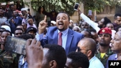 FILE - Jawar Mohammed, center, a member of the Oromo ethnic group who has been a public critic of Ethiopian Prime Minister Abiy Ahmed, addresses supporters outside his home in Addis Ababa, Oct. 24, 2019.