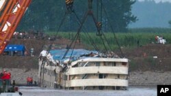 Regu penyelamat menyaksikan pengangkatan kapal Eastern Star yang terbalik di sungai Yangtze di provinsi Hubei, China, dengan menggunakan derek (5/6). 