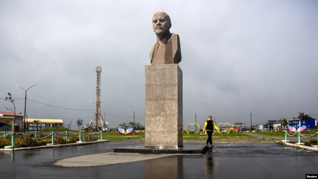 Một phụ nữ đi ngang bức tượng Lenin tại Yuzhno-Kurilsk, khu định cư chính trên đảo Nam Kuril của Kunashir, ngày 17/9/2015. Liên Xô đã chiếm quần đảo này vào năm 1945, không lâu trước khi Nhật Bản đầu hàng trong Thế chiến Thứ hai, và trục xuất 17.000 người Nhật sinh sống trên những hòn đảo đó.