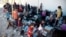 FILE - Displaced women and children sit on the ground at a collection point for internal refugees west of Mosul, Iraq, Aug. 12, 2017. 