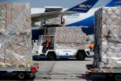FILE - Workers unload a cargo plane at Eleftherios Venizelos International Airport in Athens, March 31, 2020. The plane, carrying more than 13 million surgical masks, has arrived in Greece as part of a major shipment of medical supplies from China.