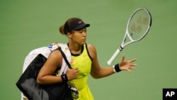Naomi Osaka of Japan tosses her racket to herself after losing to Leylah Fernandez of Canada during the third round of the US Open tennis championships, Sept. 3, 2021, in New York. 