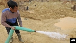 A worker waters the site of a rare earth metals mine at Nancheng county, Jiangxi province December 29, 2010.