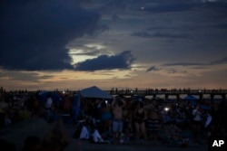 The Isle of Palms beach turns dark during the solar eclipse Monday, Aug. 21, 2017, on the beach at Isle of Palms, South Carolina.