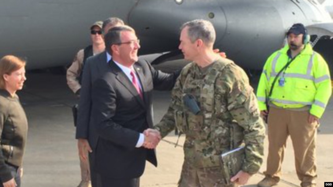 FILE - U.S. Defense Secretary Ash Carter greets Army Lt. Gen. Sean MacFarland after arriving in Baghdad, Dec. 16, 2015. 