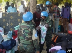 FILE - U.N. peacekeepers hold a baby as South Sudanese civilians seek protection at a U.N. camp in Juba, South Sudan, July 14, 2016.