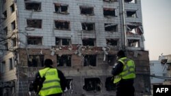 Сотрудники полиции осматривают поврежденное здание после ракетного обстрела в Киеве 12 февраля 2025 года