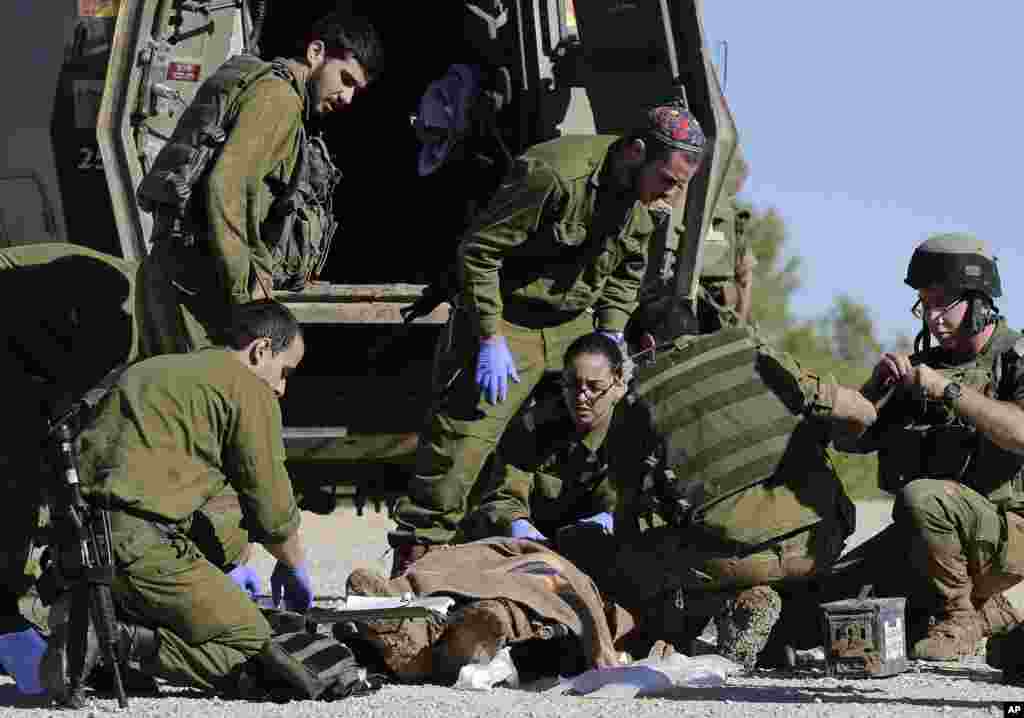 Israeli army paramedics treat a civilian shot near the Israel and Gaza border who eventually died of his wounds, Dec. 24, 2013. 