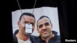 FILE - Nira Herman Sharabi, 54, wears a T-shirt with the photos of her husband Eli Sharabi, 51, and his brother Yossi, 53, at Beer Sheva, Israel, December 19, 2023