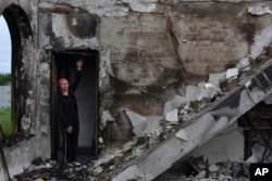 FILE - Valentina, 53, a local woman, stands inside the Evangelical Christian Baptists' prayer house in Orihiv, Ukraine, May 22, 2023, which was destroyed the previous day by a Russian attack.