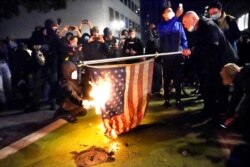 A protester lights an American flag on fire during a demonstration, Nov. 4, 2020, in Portland, Ore.