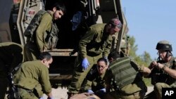 Des ambulanciers paramédicaux de l'armée israélienne traitent des civils touchés par des balles près de la frontière entre Israël et Gaza, le 24 décembre 2013.